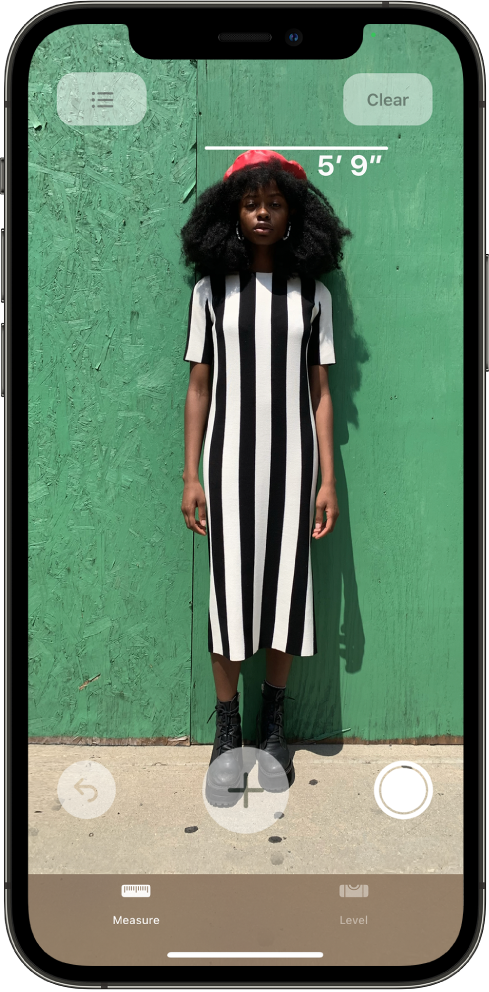 A person’s height is measured, with the height measurement showing at the top of the person’s head. The Take Picture button is active on the right edge for taking a picture of the measurement. The green Camera In Use indicator appears at the top right.