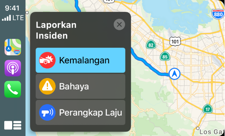 CarPlay menunjukkan ikon untuk Peta, Podcasts dan Telefon di bahagian kiri serta peta kawasan semasa di bahagian kanan melaporkan Kemalangan Trafik, Bahaya, atau Perangkap Laju.