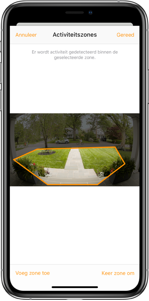 Het iPhone-scherm met een activiteitszone in een foto die door een deurbelcamera is gemaakt. De activiteitszone omvat een veranda en een pad naar de voordeur, maar niet de straat en de oprit. Boven de foto staan de knoppen 'Annuleer' en 'Gereed'. Eronder staan de knoppen 'Voeg zone toe' en 'Keer zone om'.