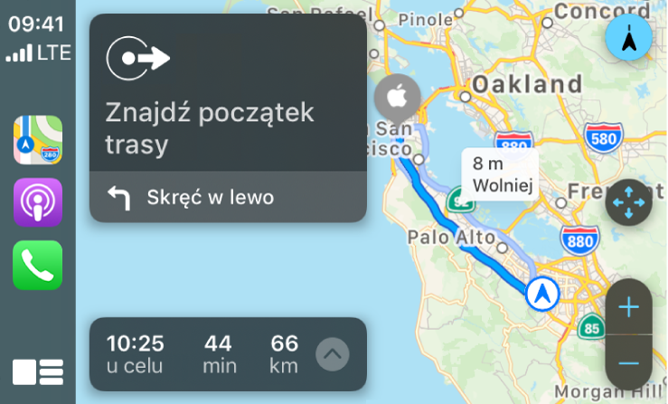 CarPlay z ikonami aplikacji Mapy, Podcasty i Telefon po lewej. Po prawej znajduje się mapa trasy przejazdu, zawierająca elementy sterujące do powiększania i pomniejszania, wskazówki krok po kroku oraz szacowany czas przybycia do celu.