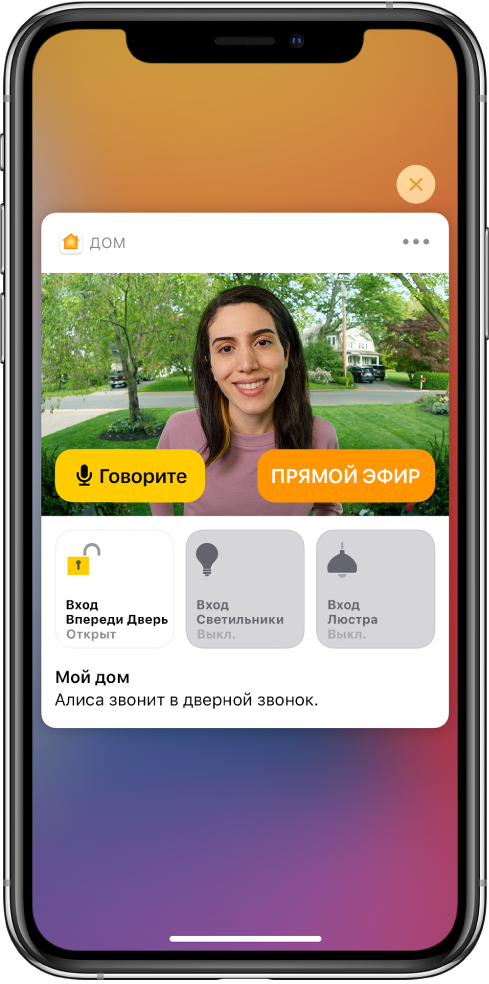 Уведомление из приложения «Дом» отображается на экране iPhone. На нем изображен человек у входной двери и кнопка «Говорите» слева. Ниже расположены кнопки аксессуаров для управления входной дверью и освещением при входе. Слова «Саша звонит в дверь». Кнопка «Закрыть» находится в правом верхнем углу уведомления.