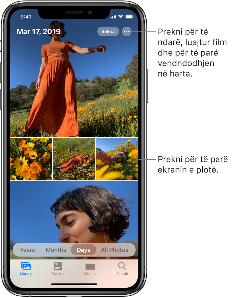 Fototeka e shfaqur në pamjen Days. Një përzgjedhje e miniaturave të fotove mbush ekranin. Në të majtë lart të ekranit ndodhet data dhe vendndodhja ku janë shkrepur fotot. Në krye djathtas ndodhen butonat Select dhe More Options për të ndarë fotot dhe për të parë detajet. Poshtë miniaturave janë opsionet për ta parë fototekën sipas Years, Months, Days dhe All Photos. Përgjatë fundit ndodhen skedat Library, For You, Albums dhe Search.
