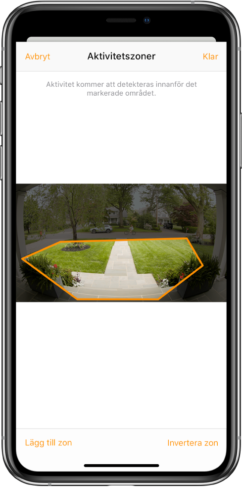 iPhone-skärmen med en aktivitetszon inom en bild tagen av en dörrklockskamera. Aktivitetszonen täcker en veranda och trädgårdsgång, men utesluter gatan och garageuppfarten. Ovanför bilden finns knapparna Avbryt och Klar. Nedanför finns knapparna Lägg till zon och Invertera zon.