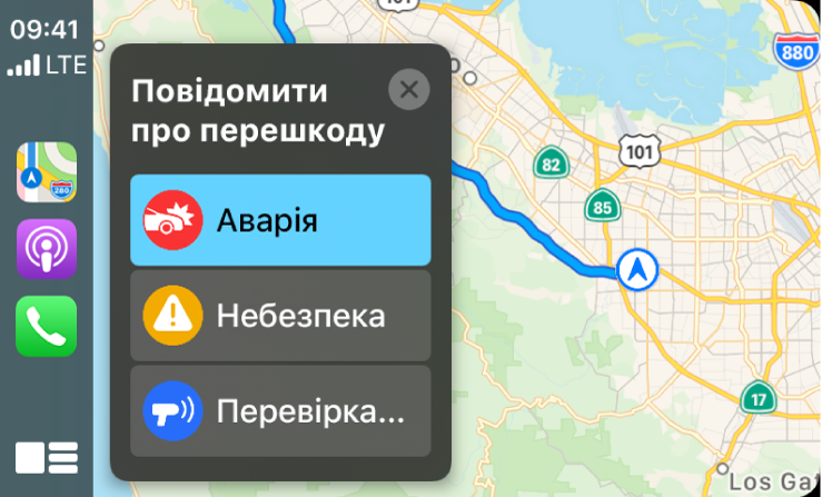 Екран CarPlay з іконками для Карт, Подкастів і Телефону ліворуч і картою поточної області праворуч, де розміщено повідомлення про ДТП, небезпеку чи контроль швидкості.