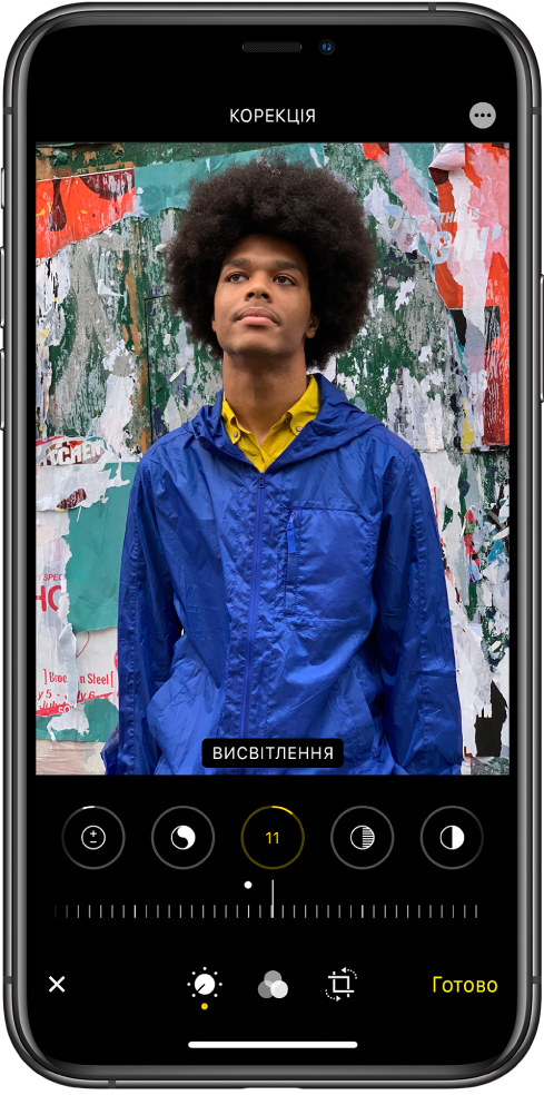 Екран редагування з фотографією в центрі. Під фотографією розташовані кнопки для редагування «Виділення», «Тіні», «Яскравість», «Чорна точка» та «Насиченість». Вибрано кнопку «Яскравість». Під кнопками для редагування є повзунок, який дає змогу налаштувати рівні яскравості. Під повзунком зліва направо розташовані кнопки «Скасувати», «Змінити», «Фільтри», «Обрізати» та «Готово». Кнопка «Більше опцій» розташована у верхньому правому куті.