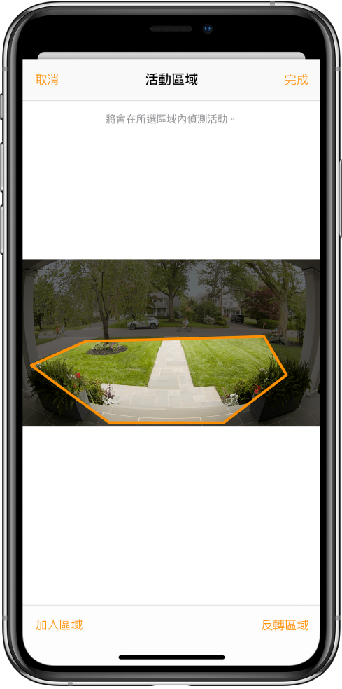 iPhone 螢幕顯示門鐘攝影機拍攝的影像中的活動區域。活動區域包含門廊和走道，但不包括街道車道。影像上方有「取消」和「完成」按鈕。「加入區域」和「反轉區域」位於下方。