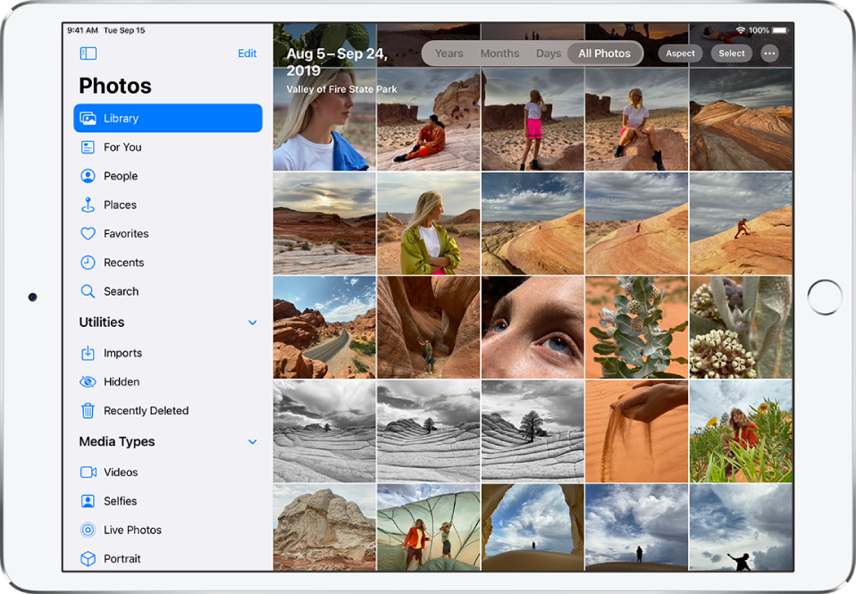 On the left side of a screen in Photos is a sidebar to select Library, For You, People, Places, and other categories; Library is selected. The rest of the screen shows the photo library in All Photos view. At the top of the photo library is the date and location where the photos were taken. In the top center are options to view photos by Years, Months, Days, and All Photos; All Photos is selected. In the top right of the screen are the Aspect, Select, and More buttons.
