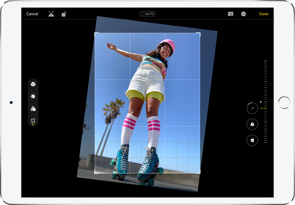 iPad in landscape orientation. In the center of the screen is a photo in Edit mode with an overlay grid and a crop frame. On the left side of the screen, the Crop button is selected. On the right side of the screen are the geometry enhancement options. Straighten is selected and the intensity slider is adjusted to -5.