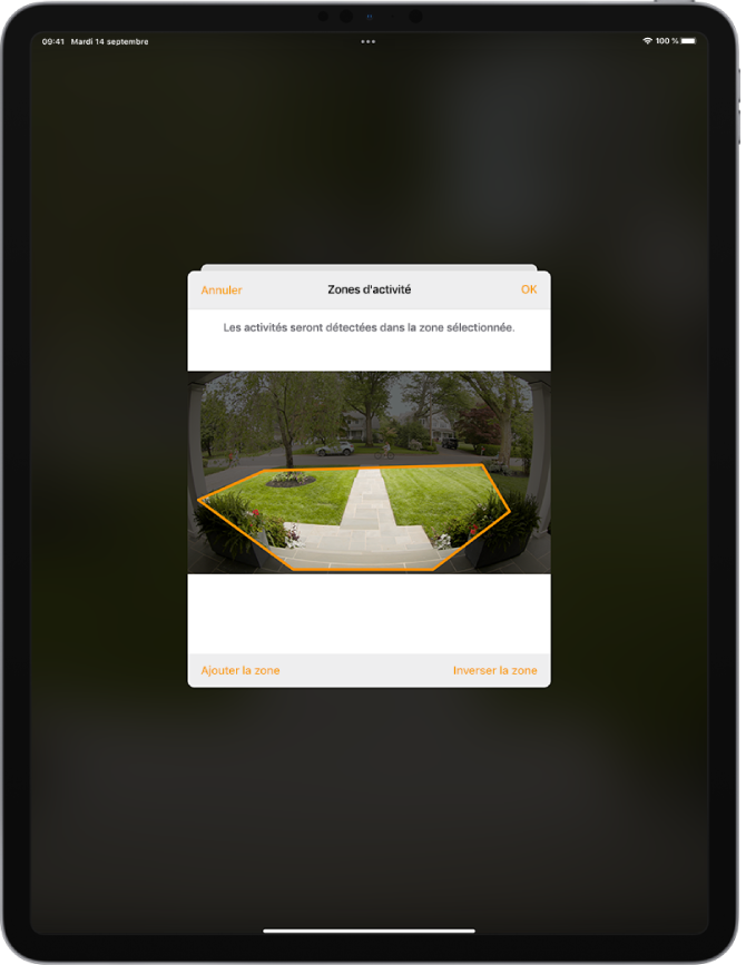 Écran d’iPad montrant une zone d’activité dans une image prise par une caméra de porte. La zone d’activité inclut un perron et une allée, mais exclut la rue et la voie d’accès. Les boutons Annuler et OK se trouvent au-dessus de l’image. Les boutons « Ajouter la zone » et « Inverser la zone » se trouvent en dessous.