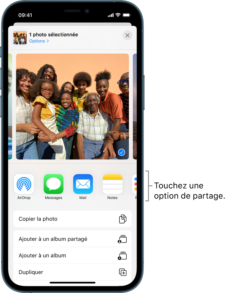L’écran Partage avec des photos affichées en haut ; deux d’entre elles sont sélectionnées, comme indiqué par la coche blanche dans un rond bleu. Le rang sous les photos présente les amis avec lesquels vous pouvez les partager à l’aide d’AirDrop. D’autres options de partage sont proposées en dessous, notamment, de gauche à droite : Messages, Mail, Albums partagés et Ajouter à Notes. Le rang du bas contient les boutons suivants : Copier, Copier le lien iCloud, Diaporama, AirPlay, et Ajouter à un album.