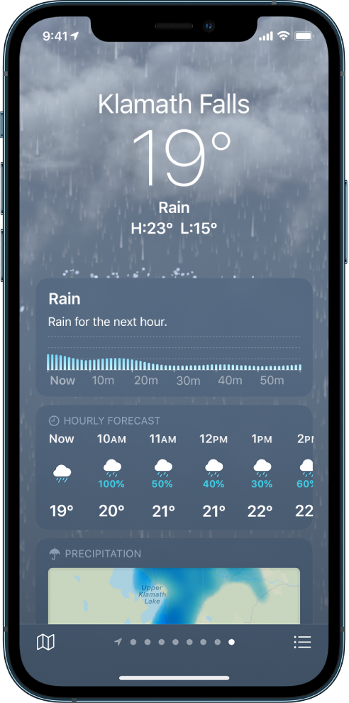 На экране приложения «Погода» отображается геопозиция вверху, текущая температура и погодные условия, а именно дождь. Ниже расположен график с уровнем осадков на каждые 10 минут в течение следующего часа. Ниже расположены почасовой прогноз погоды и карта осадков. В правом нижнем углу расположена кнопка «Список мест», а в левом нижнем углу — кнопка «Показать карту».