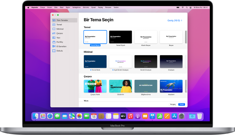Ekranda Keynote tema seçicinin açık olduğu bir MacBook Pro. Sol tarafta Tüm Temalar kategorisi seçili, sağ tarafta ise kategoriye göre satırlar halinde önceden tasarlanmış temalar görünüyor. Dil ve Bölge açılır menüsü sol alt köşede, Standart ve Geniş açılır menüsü ise sağ üst köşede yer alır.