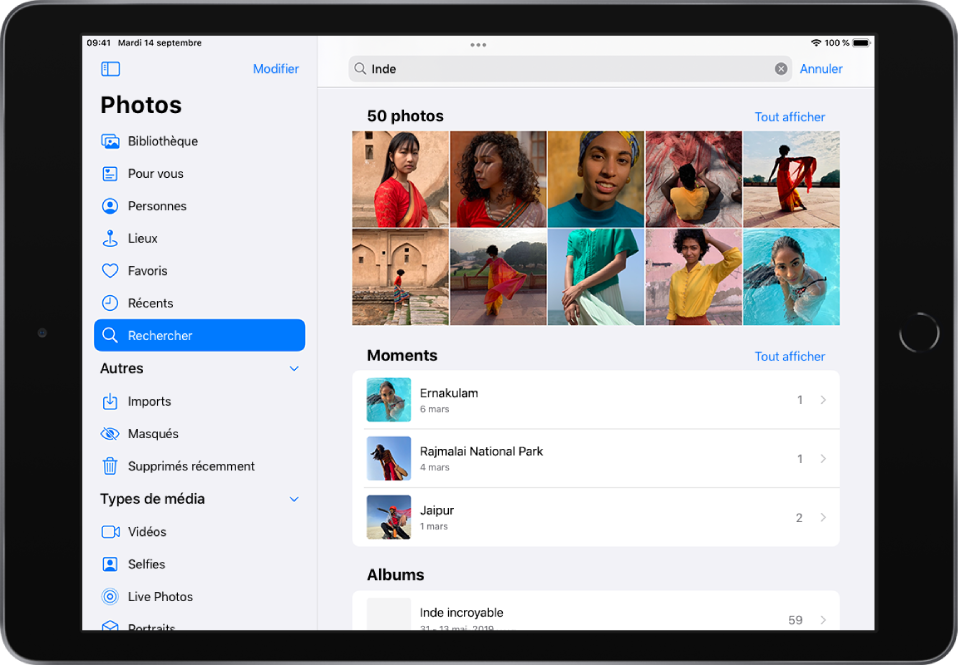 L’app Photos est ouverte en orientation paysage. À gauche de l’écran, la barre latérale affiche les boutons Photos, Pour vous, Albums et Rechercher ; le bouton Rechercher est sélectionné. Un champ de recherche est disponible en haut de l’écran ; un lieu et des dates ont été saisis dans ce champ. Des suggestions de résultats de recherche sont affichées sous le champ de recherche. Une grille de photos obtenues à partir des termes recherchés occupe le milieu de l’écran. Le nombre total de photos issues de la recherche est indiqué en haut à gauche de la grille de photos. En haut à droite de la grille de photos se trouve un bouton Tout afficher.