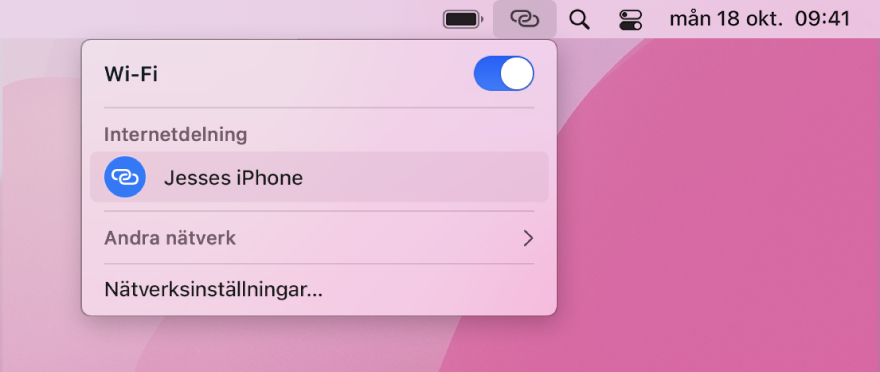 En Mac-skärm med Wi‑Fi-menyn som visar en anslutning via Internetdelning på iPhone.