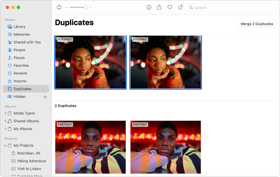 The Photos window showing Duplicates selected in the sidebar and duplicate photos side by side on the right.