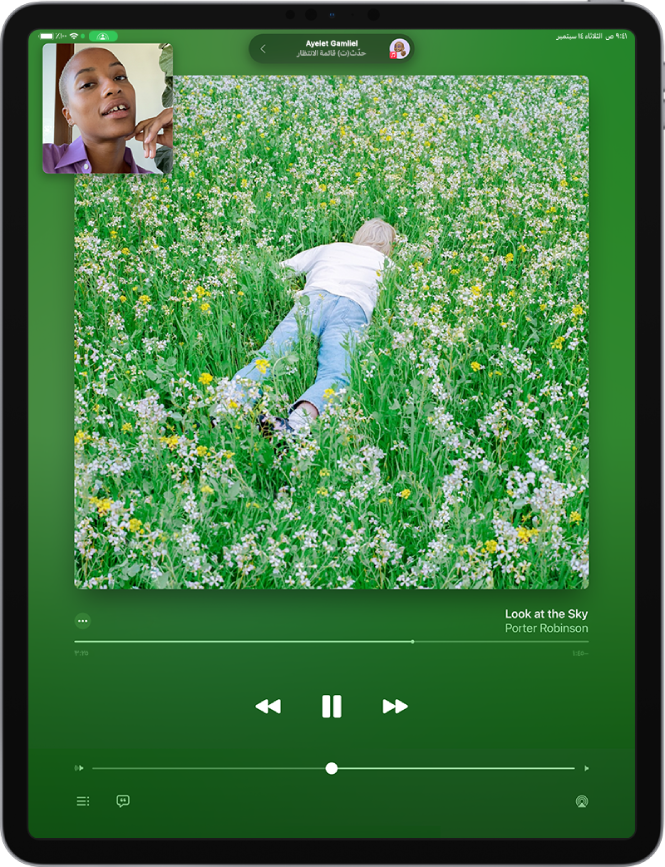 مكالمة FaceTime، تعرض محتوى صوتي من Apple Music تتم مشاركته في المكالمة. يظهر غلاف الألبوم بالقرب النصف العلوي من الشاشة، ويظهر أسفله مباشرةً العنوان وعناصر التحكم في الصوت.