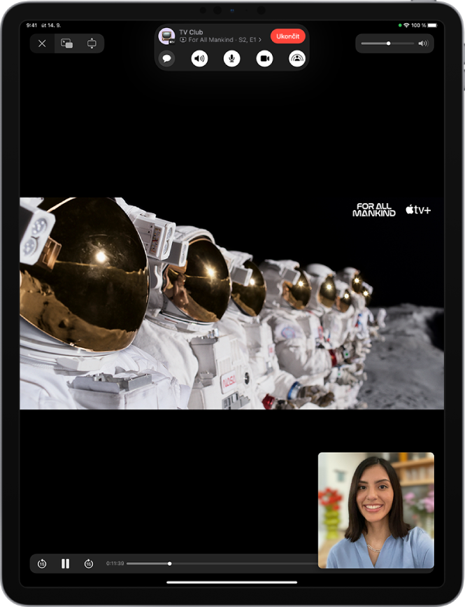 Hovor FaceTime, ve kterém se zobrazuje sdílené video z Apple TV+. U horního okraje obrazovky jsou umístěny ovládací prvky FaceTimu, pod nimi přehrávané video a u dolního okraje obrazovky ovládací prvky pro přehrávání.