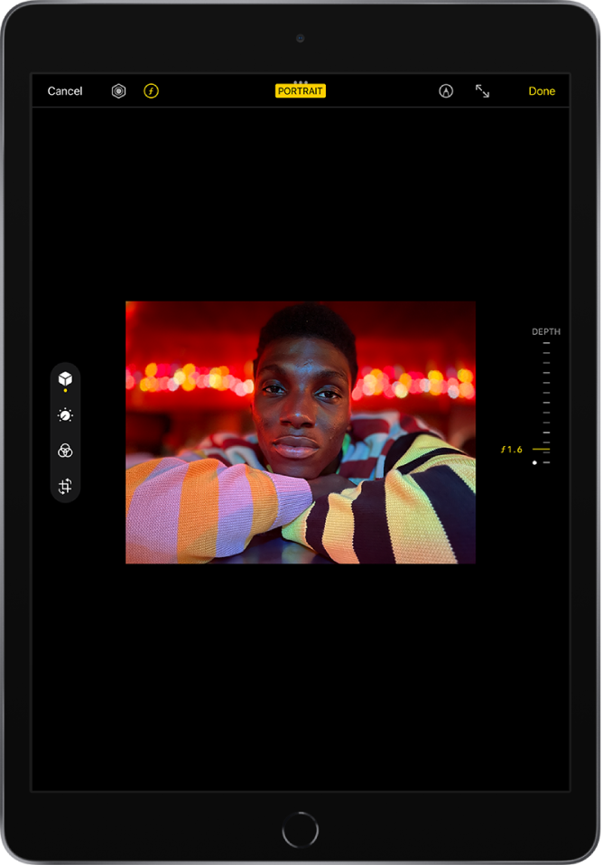Vertikalaus režimo nuotrauka „Edit“ ekrano centre. Viršutiniame kairiajame kampe yra mygtukai „Cancel“, „Light Control“ ir „Depth Adjustment“; pasirinktas mygtukas „Depth Adjustment“. Ekrano viršuje centre įjungtas mygtukas „Depth Effect“. Viršutiniame dešiniajame kampe yra mygtukai „Mark Up“, „Enter Full Screen“ ir „Done“. Redagavimo įrankiai yra kairėje ekrano pusėje (iš viršaus į apačią): „Portrait Controls“, „Adjust“, „Filters“ ir „Crop“. Pasirinktas įrankis „Portrait Controls“. Dešinėje ekrano pusėje yra slankiklis „Depth Adjustment“, skirtas koreguoti intensyvumą.