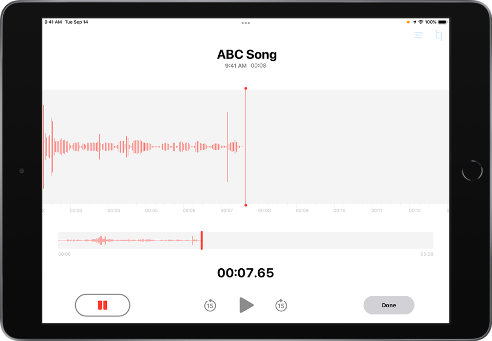 „Voice Memos“ vykstantis įrašymas ir aktyvus mygtukas „Pause“ bei pritemdyti atkūrimo valdikliai, peršokantys 15 sekundžių pirmyn arba atgal. Pagrindinėje ekrano dalyje rodoma vykstančio įrašymo bangos forma kartu su laiko indikatoriumi. Oranžinis naudojamo mikrofono indikatorius rodomas viršuje, dešinėje.