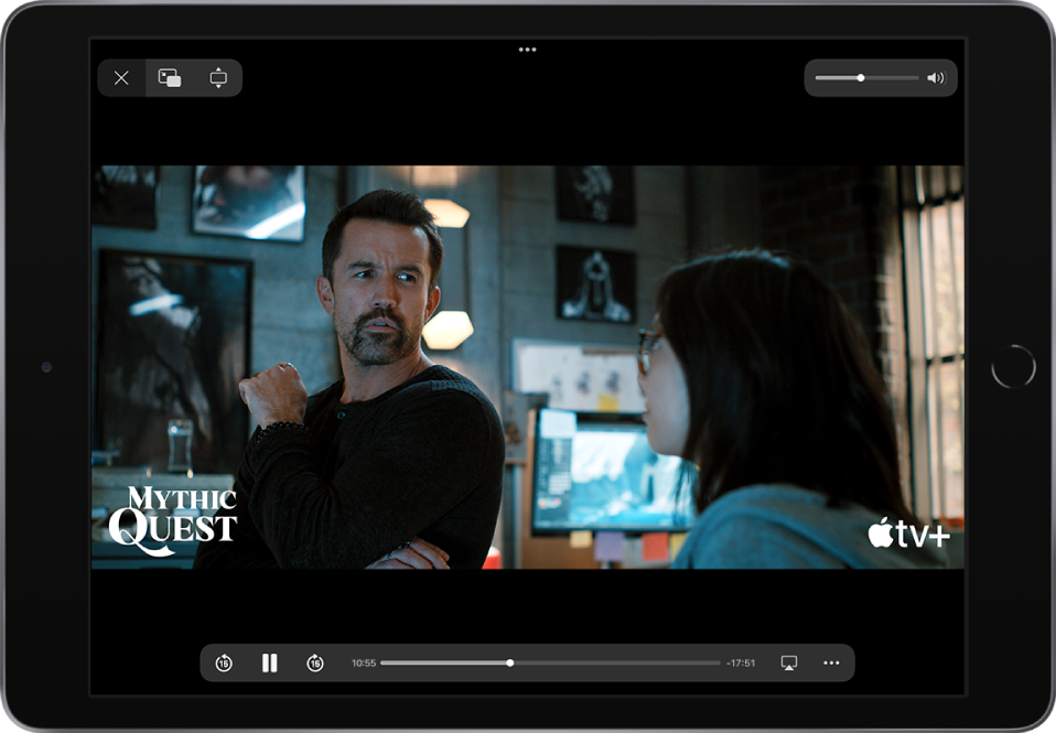 Filem dimainkan, dengan kawalan ditunjukkan. Butang Tutup, Gambar dalam Gambar dan Zum berada di bahagian kiri atas. Gelangsar kelantangan berada di bahagian kanan atas. Di bahagian kiri bawah, terdapat butang untuk melangkau 15 saat ke belakang, menjeda dan melangkau 15 saat ke depan. Merentas bahagian tengah bawah ialah gelangsar yang anda boleh seret untuk melaraskan kedudukan video; masa berlalu dan baki masa muncul di kedua-dua sisi gelangsar. Di bahagian kanan bawah, terdapat butang untuk menukar destinasi video dan menunjukkan lebih banyak kawalan.