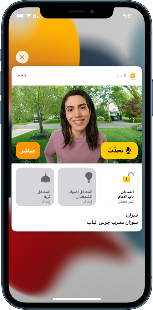 إشعار من تطبيق المنزل على شاشة الـ iPhone. يعرض صورة شخص عند الباب الأمامي مع ظهور زر تحدث على اليمين. أسفل ذلك تظهر أزرار الملحقات للباب الأمامي ومصابيح المدخل. وتظهر الكلمات "تدق رشا جرس الباب". ويوجد زر إغلاق في أعلى يسار الإشعار.