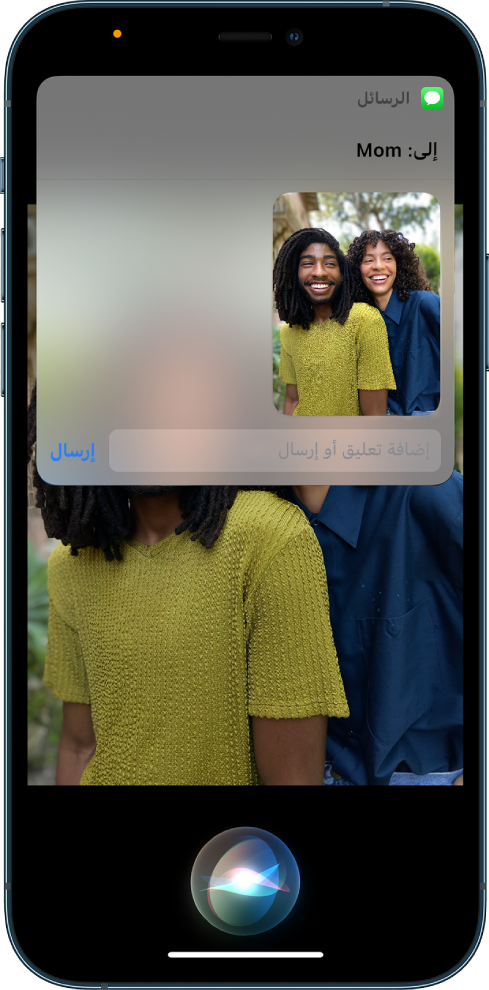 تطبيق الصور مفتوح وتظهر به صورة لشخصين. في الجزء العلوي من الصورة رسالة موجهة إلى أمي، والتي تتضمن نفس الصورة. يظهر Siri في أسفل الشاشة.
