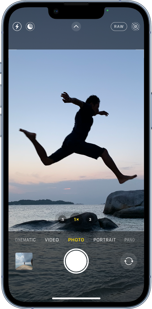 The Camera screen in Photo mode, with other modes to the left and right below the viewfinder. The buttons for Flash, Night mode, Camera Controls, ProRaw, and Live Photo are at the top of the screen. Below the camera modes are, from left to right, the Photo and Video Viewer button, the Take Picture button, and the Camera Chooser Back-Facing button.