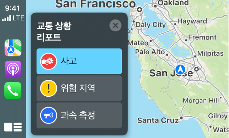 왼쪽에는 지도, 팟캐스트, 전화 아이콘, 오른쪽에는 교통 사고, 위험 지역 또는 과속 측정을 리포트하는 현 위치의 지도를 표시하는 CarPlay.