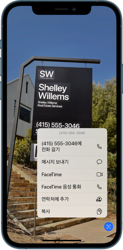 전체 화면에 열려 있는 사진. 사진에는 텍스트와 전화번호가 포함된 간판이 있음. 전화번호가 선택되고 화면에 전화, 메시지 보내기, FaceTime, FaceTime 음성 통화, 연락처에 추가 및 복사 옵션이 표시됨.