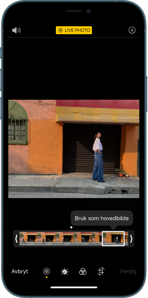 En Live Photo-skjerm med Live Photo-bildet midt på. Live-knappen er øverst på midten, og Lyd-knappen er øverst til høyre. Under bildet er bildevisningen med Bruk som hovedbilde-knappen aktiv. På hver side av bildevisningen er det to piler som du kan bruke til å klippe Live Photo-bildet.