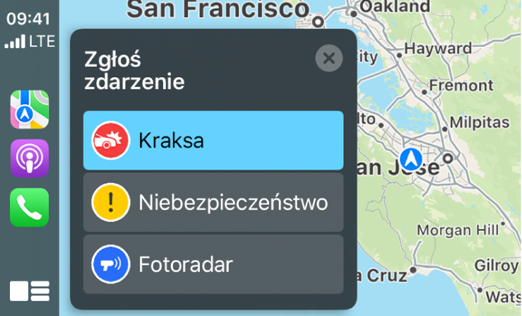 CarPlay z ikonami aplikacji Mapy, Podcasty i Telefon po lewej oraz mapą bieżącego obszaru po prawej. Widoczne są opcje zgłaszania wypadku, niebezpieczeństwa i fotoradaru.