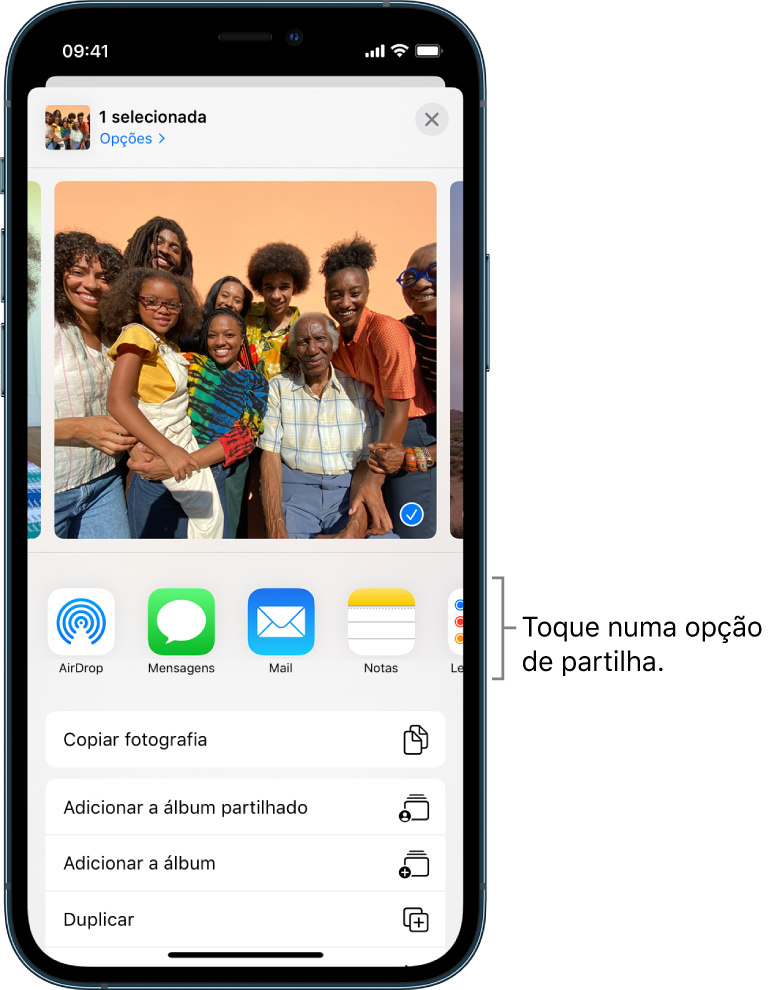 O ecrã de partilha com fotografias ao longo da parte superior; duas fotografias estão selecionadas, indicadas com uma marca de verificação branca num círculo azul. A fila por baixo das fotografias mostra amigos com os quais pode partilhar através de AirDrop. Por baixo encontram‑se outras opções de partilha incluindo, da esquerda para a direita, Mensagens, Mail, “Álbuns partilhados” e “Adicionar a Notas”. Na última linha encontram‑se os botões Copiar, “Copiar ligação iCloud”, Diaporama, AirPlay e “Adicionar a álbum”.