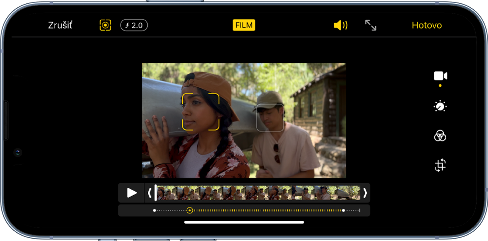 Obrazovka úprav videa zhotoveného vo filmovom režime s orientáciou na šírku. V ľavej hornej časti obrazovky sa nachádza tlačidlo Zrušiť, tlačidlo príručky filmového režimu a tlačidlo na úpravu hĺbky. V strede hore je vybrané tlačidlo filmového režimu. V pravej hornej časti obrazovky je tlačidlo hlasitosti, tlačidlo zobrazenia na celej obrazovke a tlačidlo Hotovo. Video je v strede obrazovky a okolo zaostreného subjektu je rámček. Pod videom je prehliadač snímok, v ktorom sa zobrazuje miesto vo videu, na ktorom sa zmení zaostrený subjekt. Na pravej strane obrazovky sa nachádzajú nástroje na úpravy (zhora nadol): Video, Upraviť farbu, Filter a Orezať.
