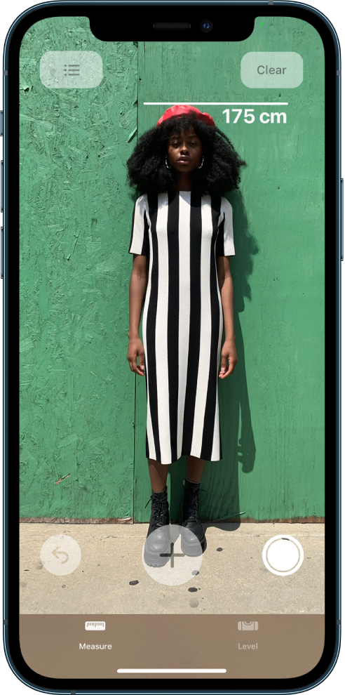 Telesna višina posameznika je izmerjena tako, da je meritev višine prikazana nad glavo posameznika. Gumb Take Picture se aktivira blizu spodnjega desnega roba, če želite posneti meritev. Zgoraj desno se prikaže zeleni indikator Camera In Use.