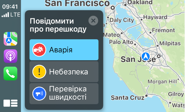 Екран CarPlay з іконками для Карт, Подкастів і Телефону ліворуч і картою поточної області праворуч, де розміщено повідомлення про ДТП, небезпеку чи контроль швидкості.