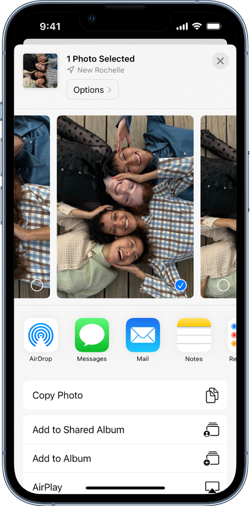 The Sharing screen with photos across the top; two photos are selected, indicated with a white checkmark in a blue circle. The row beneath the photos shows friends you can share with using AirDrop. Below that are other sharing options, including, from left to right, Messages, Mail, Shared Albums, and Add to Notes. In the bottom row are the Copy, Copy iCloud Link, Slideshow, AirPlay, and Add to Album buttons.