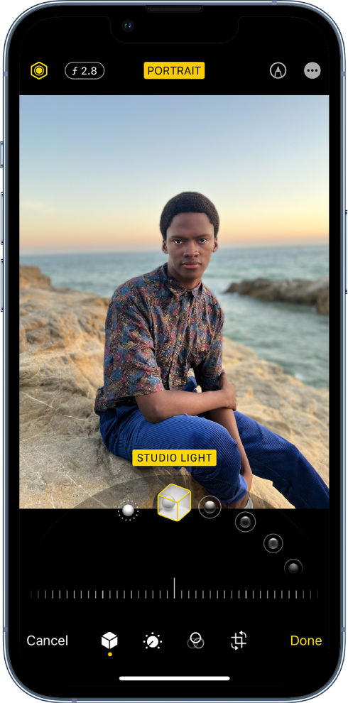 The Edit screen of a Portrait mode photo. At the top left of the screen are the Lighting Intensity button and the Depth Adjustment button. At the top center of the screen, the Portrait button is on, and at the top right is the Mark Up button. The photo is in the center of the screen and below the photo is a slider to choose the Portrait Light Effect. Below that is a slider to adjust the value. At the bottom of the screen from left to right are the Cancel, Portrait, Adjust, Filters, Crop, and Done buttons.