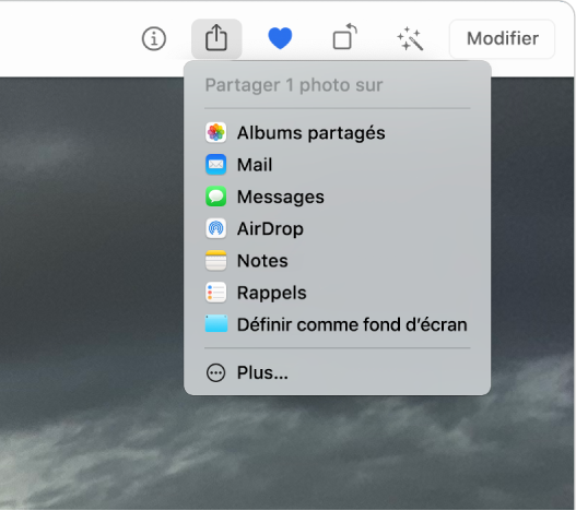 Le menu Partager, accédé avec le bouton Partager dans la barre d’outils de Photos. Le menu Partager contient, de haut en bas, Albums partagés, Mail, Messages, AirDrop, Notes, Rappels et Définir comme fond d’écran. La dernière option est Plus.