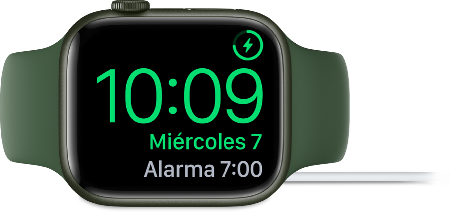 Un Apple Watch colocado de lado y conectado al cargador, con la pantalla mostrando el símbolo de carga en la esquina superior derecha, la hora actual debajo y la hora de la siguiente alarma.