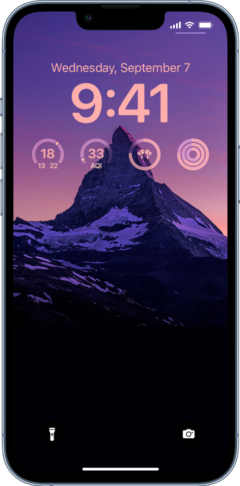 Uma Tela Bloqueada personalizada de um iPhone, com uma foto no fundo e widgets de temperatura, qualidade do ar, nível da bateria dos AirPods e círculos de preparo físico na parte superior da tela.