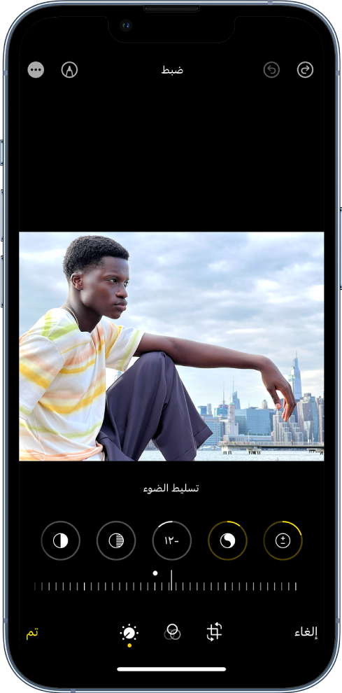 شاشة تحرير مع عرض صورة في المنتصف. أسفل الصورة توجد أزرار تحرير للتحسين والتعرُّض للضوء والتألق والتمييزات. تم تحديد الإضاءة. أسفل أزرار التحرير، يوجد شريط تمرير لضبط مستويات الإضاءة. أسفل شريط التمرير، من اليمين إلى اليسار تظهر الأزرار ضبط والفلاتر واقتصاص وتم. زر توصيف موجود في الزاوية العلوية اليسرى.