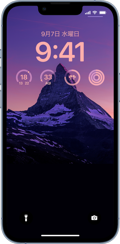 パーソナライズされたiPhoneのロック画面。背景には写真が表示され、画面の上部には気温、空気質指数、AirPodsのバッテリー残量、フィットネスリングのウィジェットがあります。
