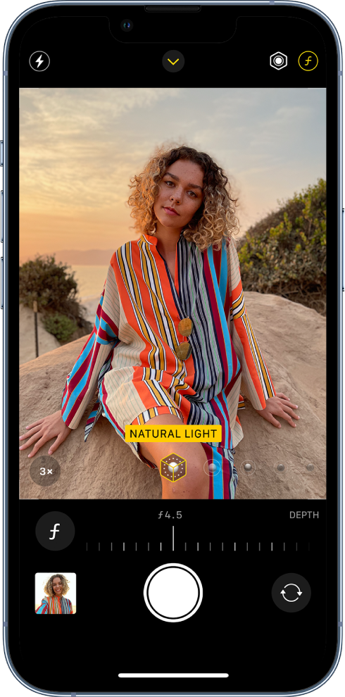 Fotoaparato ekranas režimu „Portrait“. Pasirinktas „Depth Adjustment“ mygtukas viršutiniame dešiniajame ekrano kampe. Kameros vaizdo ieškiklyje rodoma, kad „Portrait Lighting“ apšvietimo parinktis nustatyta kaip „Natural Light“ apšvietimas, o apšvietimą galite pakeisti slankikliu. Žemiau kameros vaizdo ieškiklio yra „Depth Control“ reguliavimo slankiklis.