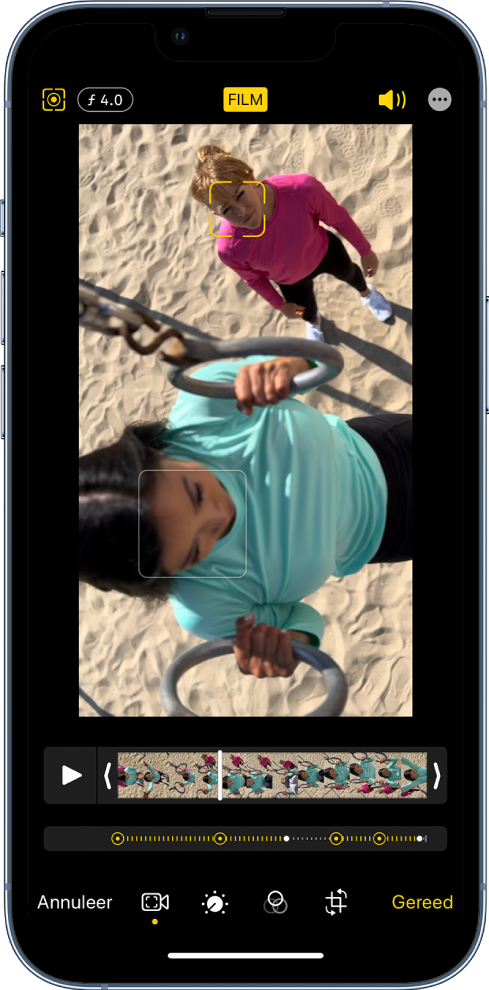 Het Wijzig-scherm van een film in de liggende stand. Linksboven in het scherm zie je de knop 'Annuleer', de knop voor de handmatige filmmodus en de knop waarmee je de scherptediepte aanpast. Middenboven in het scherm is de knop 'Film' geselecteerd. Rechtsboven in het scherm zie je de knoppen voor het volume en de schermvullende weergave en de knop 'Gereed'. De video staat in het midden van het scherm en het onderwerp is omkaderd. Onder de video staat de frameviewer waarin het punt in de video te zien is waar de focus van het onderwerp verandert. Aan de rechterkant van het scherm staan de bewerkingshulpmiddelen, van boven naar beneden: video, kleur aanpassen, filteren en bijsnijden.