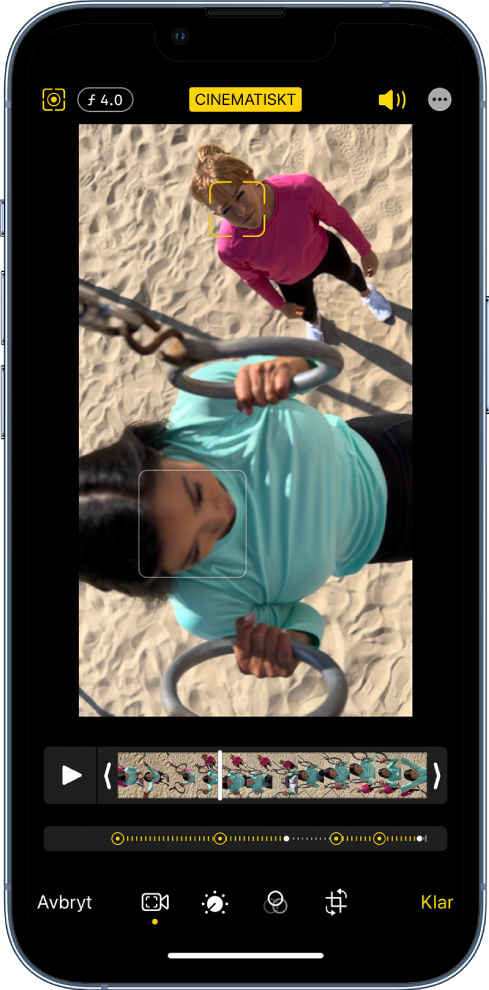 Skärmen Ändra för en video i cinematiskt läge i liggande riktning. Högst upp till vänster på skärmen finns knappen Avbryt, knappen för cinematiskt manuellt och knappen för djupjustering. Högst upp på mitten av skärmen är knappen Cinematiskt vald. Högst upp till höger på skärmen finns volymknappen, knappen för helskärmsläge och knappen Klar. På mitten av skärmen finns en video med en ram runt det som är i fokus. Under videon finns bildrutevisaren som visar den punkt i videon där fokus ändras. Till höger finns redigeringsverktygen, uppifrån och ned: Video, Justera färg, Filter och Beskär.