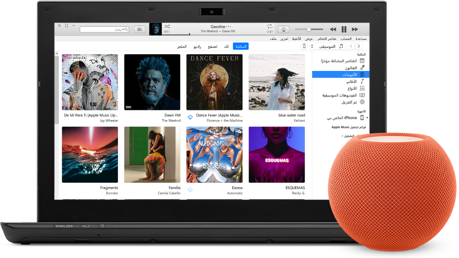 كمبيوتر PC يظهر على شاشته iTunes وبالقرب منه تظهر HomePod mini.