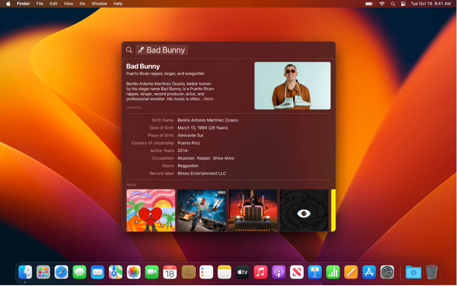 A Mac desktop with the Spotlight window open. The search results show details about a music artist and several of their albums.