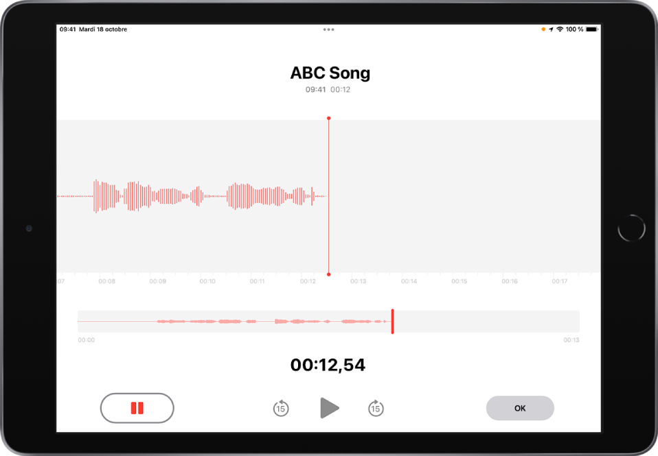Un enregistrement de mémo vocal en cours, avec un bouton Pause actif en surbrillance et des commandes grisées permettant de lire l’enregistrement, d’avancer de 15 secondes et de reculer de 15 secondes. La majeure partie de l’écran affiche la forme d’onde de l’enregistrement en cours, ainsi que sa durée. Le voyant orange « Micro en cours d’utilisation » apparaît en haut à droite.