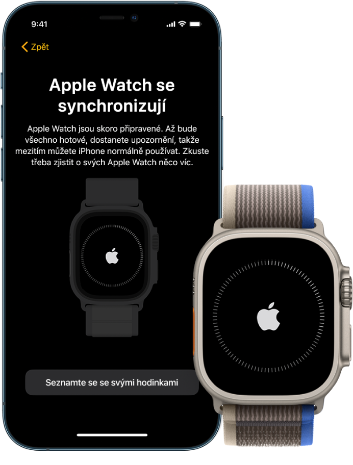 iPhone a Apple Watch Ultra ležící vedle sebe. Obrazovka iPhonu se zobrazenou zprávou „Apple Watch se synchronizují“. Apple Watch Ultra ukazují průběh synchronizace.