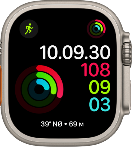 Urskiven Digital aktivitet, der viser tiden og status for dit mål for Bevægelse, Motion og Stå. Der er også tre komplikationer: Træning øverst til venstre, Aktivitet øverst til højre og komplikationen Kompas nederst.
